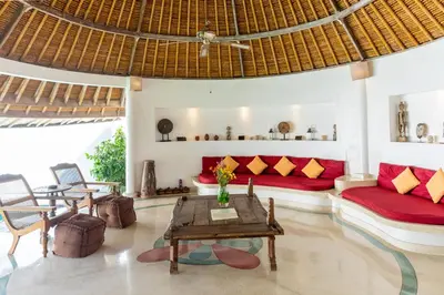 a living room with a red couch and a table at Villa Damai Kecil Seminyak by Adam Jyota Management in Seminyak