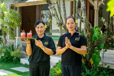 two women standing next to each other holding a tray of drinks at Villa Damai Kecil Seminyak by Adam Jyota Management in Seminyak