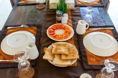 a wooden table with a plate of food and bread at Villa Damai Kecil Seminyak by Adam Jyota Management in Seminyak
