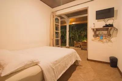 a bedroom with a bed and a tv on the wall at Bale Seminyak in Seminyak