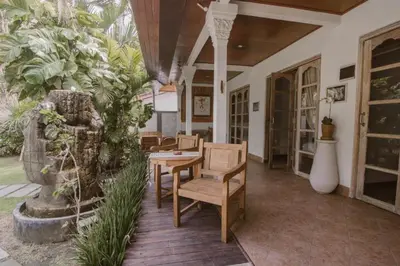 a porch with a table and chairs and plants at Bale Seminyak in Seminyak