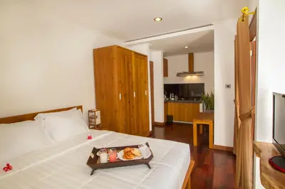 a bedroom with a bed with a tray of food on it at Delu Villas & Suite in Kerobokan