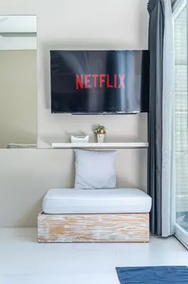 a bed in a room with a netflix sign on the wall at VILLA BALI OM CENTER - Best Location, Beautiful Villa Near the Beach in Canggu