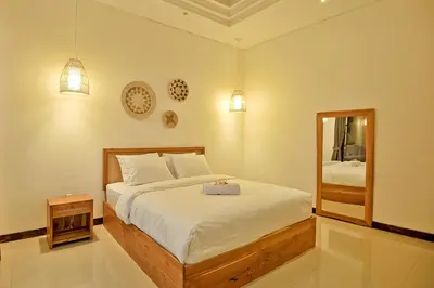 a bedroom with a large bed and a mirror at Villa Casey in Seminyak