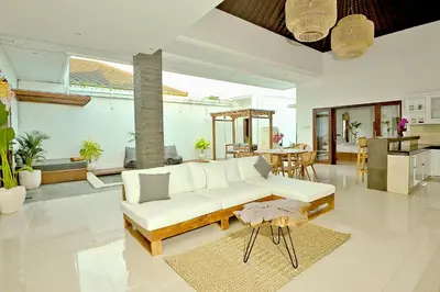 a living room with a white couch and a table at Villa Casey in Seminyak