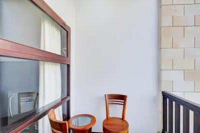 a couple of chairs sitting on a balcony at Collection O Bali near Kedonganan Beach formerly New Asta Graha Homestay in Jimbaran