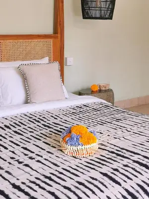 a bowl of flowers sitting on a bed at Villa Casa Orana in Seminyak