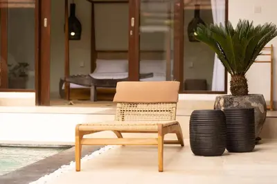 a chair and a potted plant in front of a house at Villa Casa Orana in Seminyak