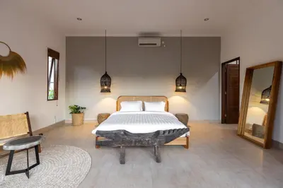 a bedroom with a bed and a table and a mirror at Villa Casa Orana in Seminyak