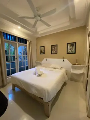a bedroom with a large white bed with a ceiling fan at Blue Lagoon 5 bedrooms Villa in Kuta