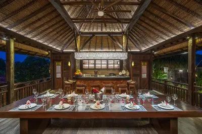 a dining room with a long table and chairs at Villa Kapungkur in Jimbaran