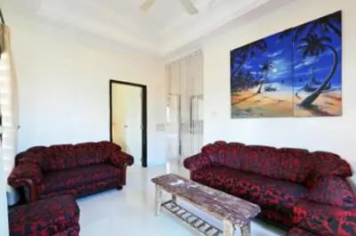 a living room with two red couches and a table at Blue Lagoon Apartment 3br in Kuta