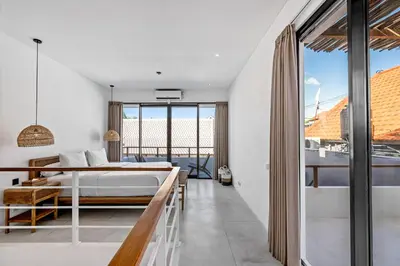 a bedroom with a bed and a balcony at Besso Villa by Betterplace in Canggu
