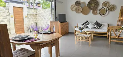 a living room with a wooden table and chairs at Villa Floppy New 1 bedr villa private Pool 5min beach in Legian