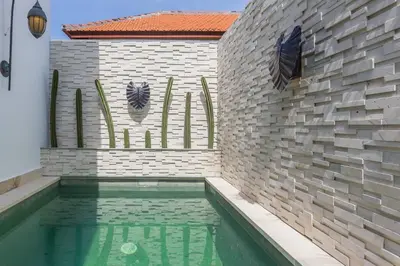 a swimming pool in front of a brick wall at Villa Floppy New 1 bedr villa private Pool 5min beach in Legian