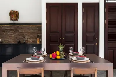 a table with a bowl of fruit and wine glasses at Villa Rua - Stylish luxury, tranquil location in Legian, walk to beach in Seminyak
