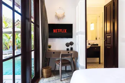a hotel room with a desk and a bed at Villa Tahi - Stylish luxury, tranquil location, walk to beach in Legian