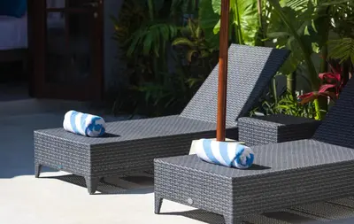 two chairs with blue and white pillows on a patio at Villa Tahi - Stylish luxury, tranquil location, walk to beach in Legian