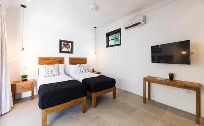 a bedroom with a bed and a tv on the wall at Villa Toru - Stylish luxury in Legian, tranquil location, walk to beach in Legian