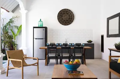a kitchen with a table with chairs and a refrigerator at Villa Toru - Stylish luxury in Legian, tranquil location, walk to beach in Legian