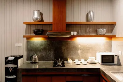 a kitchen with a stove and a microwave at Bracha Villas Bali in Seminyak