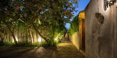 an alley with a tree and a wall at Bracha Villas Bali in Seminyak