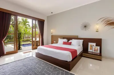 a bedroom with a bed and a large window at Bali Voyage in Seminyak
