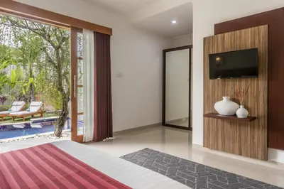 a bedroom with a flat screen tv and a bed at Bali Voyage in Seminyak