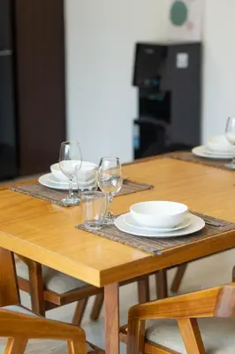 a wooden table with plates and wine glasses on it at Bali Voyage in Seminyak