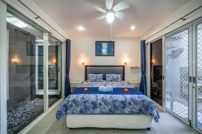 a bedroom with a bed with a blue comforter at Modern villa with private pool , full kitchen and parking in Legian