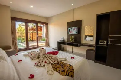 a bedroom with a bed with red flowers on it at Legian Bisma Suite in Seminyak