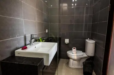 a bathroom with a sink and a toilet at Legian Bisma Suite in Seminyak