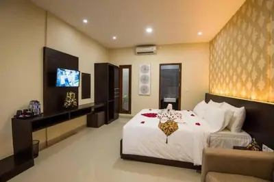 a bedroom with a large bed and a television at Legian Bisma Suite in Seminyak