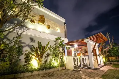 a white house with lights on the side of it at Legian Bisma Suite in Seminyak