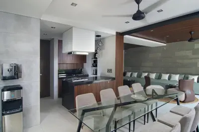 a kitchen with a glass table and white chairs at 4BR Villa Kamis - Minggu Villas Seminyak in Seminyak