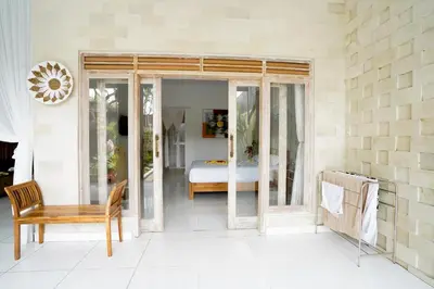 a room with a bed and a table and a chair at Villa Polly in Seminyak