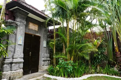 a building with palm trees in front of it at Villa Polly in Seminyak