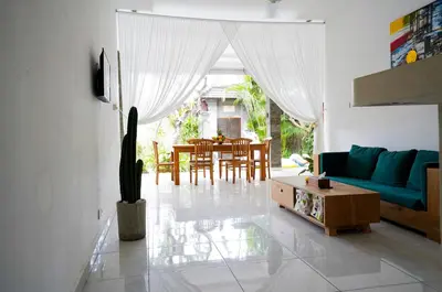 a living room with a blue couch and a table at Villa Polly in Seminyak