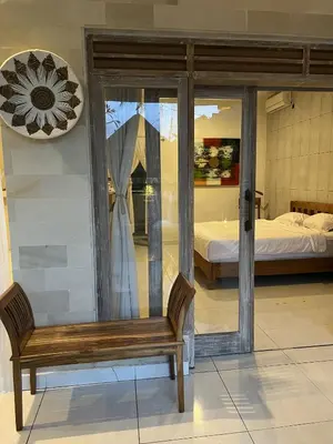 a wooden bench in a room with a bedroom at Villa Polly in Seminyak
