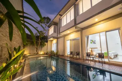 a villa with a swimming pool and a bedroom at Cozy Umalas Guesthouse in Kerobokan