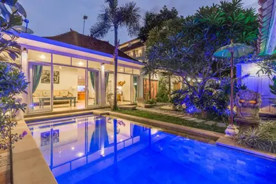 a house with a swimming pool in front of a house at Villa Maloa in Denpasar