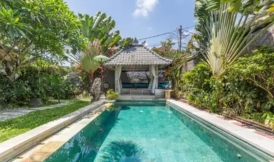 a swimming pool in a backyard with a gazebo at Villa Maloa in Denpasar