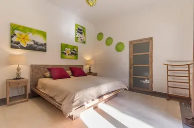 a bedroom with a bed with red pillows at Villa Maloa in Denpasar
