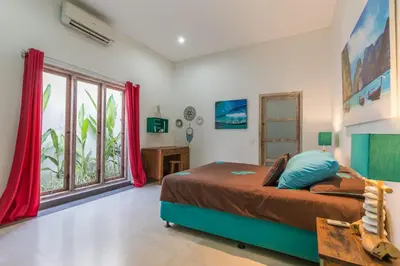 a bedroom with a bed and a large window at Villa Maloa in Denpasar