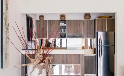 a kitchen with wooden cabinets and a refrigerator at Villa Sunset by Premier Hospitality Asia in Nusa Dua