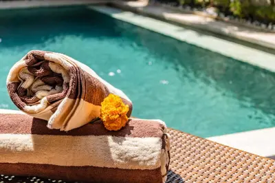 a napkin with a flower on it next to a swimming pool at NEWLY RENOVATED trendy 4bd Pvt villa in Seminyak in Seminyak