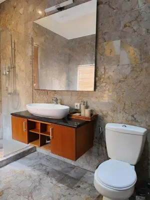 a bathroom with a sink and a toilet and a mirror at The Oasis Retreat Seminyak in Seminyak