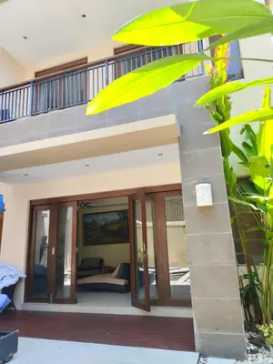 a house with glass doors and a balcony at The Oasis Retreat Seminyak in Seminyak