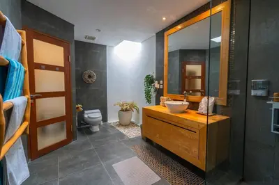 a bathroom with a sink and a mirror and a toilet at Miracle villa Canggu in Canggu