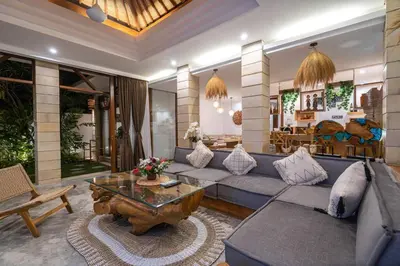 a living room with a blue couch and a table at Miracle villa Canggu in Canggu